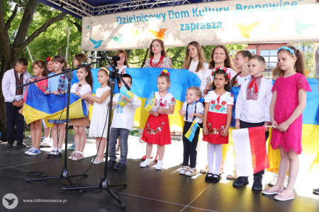 Kolorowe zdjęcie. Chór dziecięcy z flagami Ukrainy śpiewa na scenie.