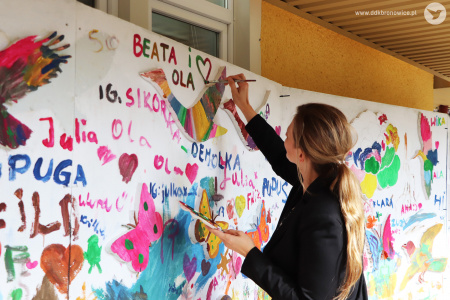 Kolorowe zdjęcie. Pani Prezydent Beata Stepaniuk-Kuśmierzak maluje pędzlem serce na wielkoformatowej ściance.