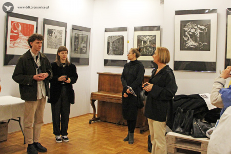 Kolorowe zdjęcie. Dwie osoby stoją na tle prac z wystawy. Agnieszka Zawadzka i Aleksandra Machowska się im przyglądają.