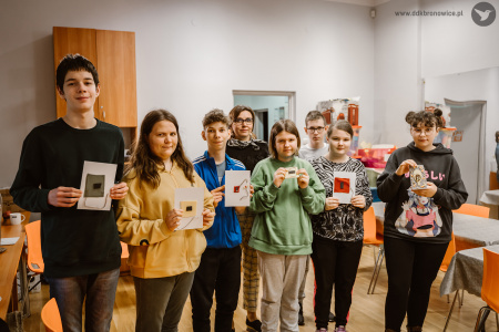 Kolorowe zdjęcie. Młodzież z Panią stoją i pozują do zdjęcia. W dłoniach trzymają wykonane strony do książek sensorycznych.