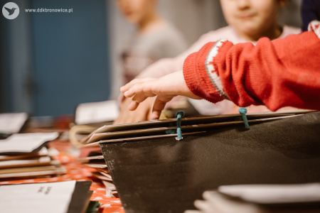 Zdjęcie kolorowe. dzieci z zainteresowaniem wodzą palcami po zawartości książek sensorycznych.
