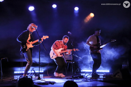 Kolorowe zdjęcie. Na scenie zespół NIEBØ - Aga Ozon, Adrian Kieroński i Piotrek Rudnicki. Wszyscy grają na gitarach.