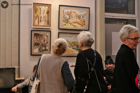 Kolorowe zdjęcie. Dwie kobiety podziwiają obraz Wiesława Stefańskiego. Kadra na kobiety od tyłu.