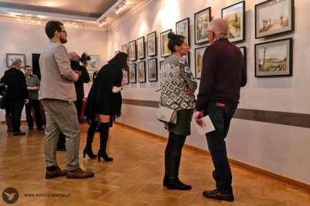 Kolorowe zdjęcie. Kilka osób uważnie ogląda obrazy Wiesława Stefańskiego.