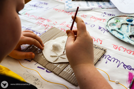 Na malej tekturce, chłopiec tworzy swoją makietę rafy koralowej.