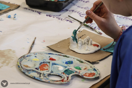 Dziewczynka maluje rafę koralową. Obok leży paleta malarska.