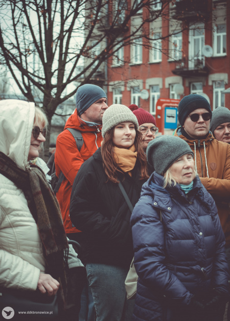 Uczestnicy spaceru z przewodnikiem. Na pierwszym planie trzy kobiety. Jedna z nich uśmiecha się.