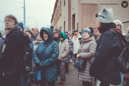 Grupa uczestników spaceru z przewodnikiem.