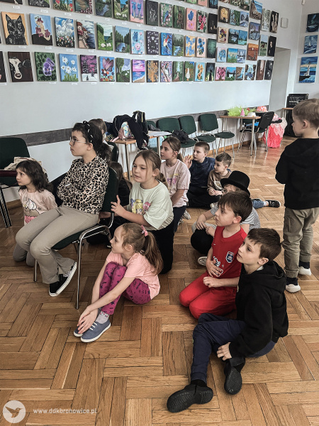 Dzieci uczestniczą w animacji na podłodze.