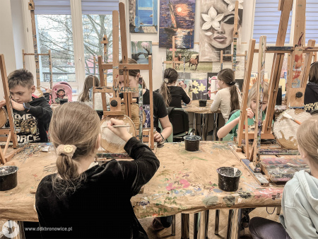 Sala warsztatowa. Dzieci malują swoje obrazy na drewnie.