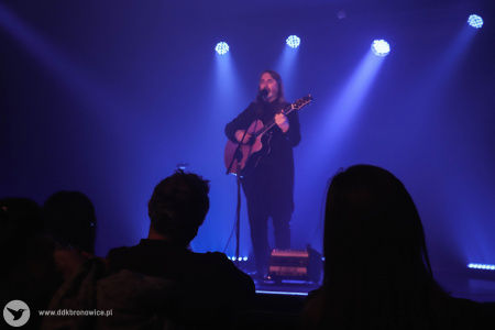 Jan Kondrak gra piosenkę. Zapalone jest niebieskie światło.