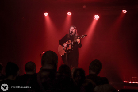 Jan Kondrak wykonuje poruszającą piosenkę. W tle świeci się klimatyczne czerwone światło.