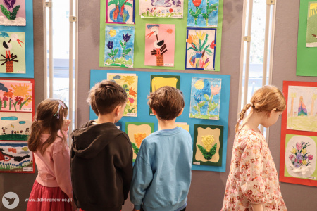 Dzieci oglądają swoje obrazy. Na pierwszym planie dwóch chłopców.