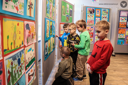Dzieci oglądają zawieszone obrazy.