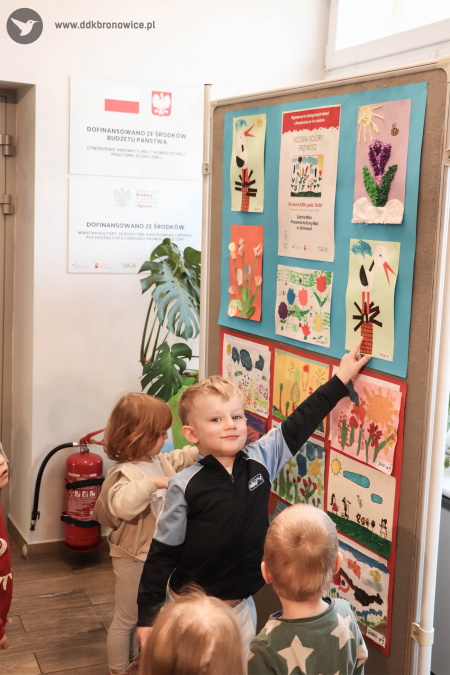 Chłopiec w granatowej bluzie pokazuje swój obraz.