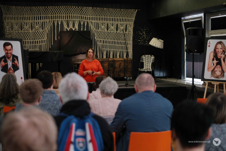 Pracownie Kultury Tatary. Sala teatralna. W pomarańczowym wygłasza przemówienie Aleksandra Machowska-Skrocka. Na pierwszym planie siedząca publiczność.