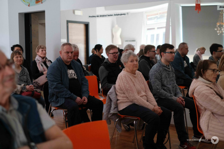 Zgromadzona publiczność. Osoby bacznie oglądają spektakl na scenie.