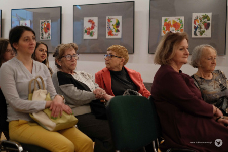 Kobiety, autorki siedzą na krzesłach, na środku Galerii Krańcowej. W tle widać zawieszone obrazy na szarych tłach.