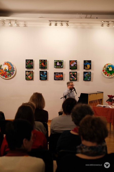 Publiczność słucha mężczyzny grającego na pianinie. Na pierwszym planie widoczna widownia.