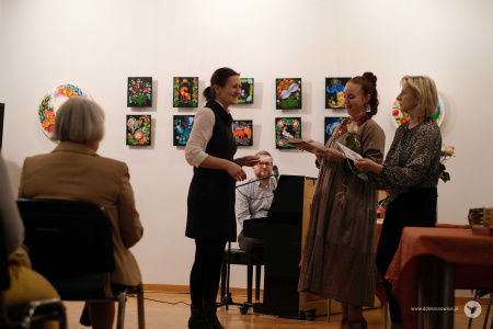 Rozdanie dyplomów i podziękowań. Autorka w białej koszuli i czarnej sukience odbiera dyplom i kwiaty.