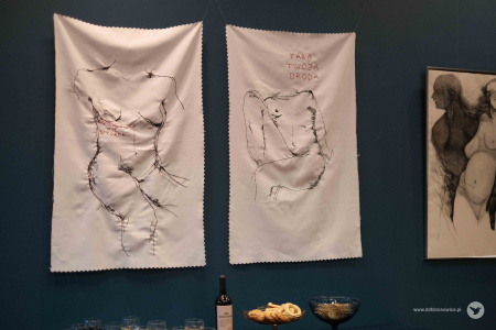 Dwa wyszywane obrazy na białej tkaninie. Przedstawiają wyszywane kontury kobiety czarna nicią. Na jednym czerwony napis: dziewczynce nie wypada. Na drugim napis: taka twoja uroda.