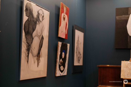 Cztery obrazy zawieszone na granatowej ścianie. Jeden z nich przedstawia mężczyznę i kobietę. Obraz jest czarno-biały.