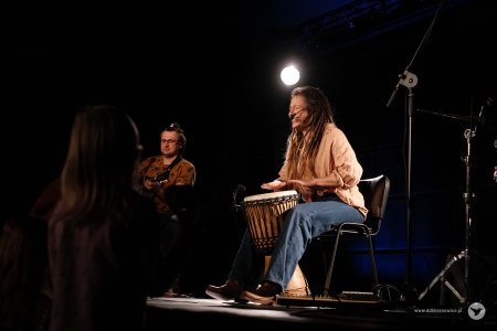 muzycy graja na swoich instrumentach na scenie.