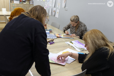 Prowadząca rozmawia z uczestniczką w czarnej bluzie. Uczestniczka stoi przy siedzącej prowadzącej.