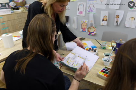 Prowadząca warsztaty rozmawia z uczestnikiem warsztatów. Namalował szaro-żółty obraz.