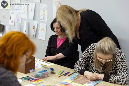 Prowadząca rozmawia z uczestniczką w czarnym swetrze i różowej bluzce.