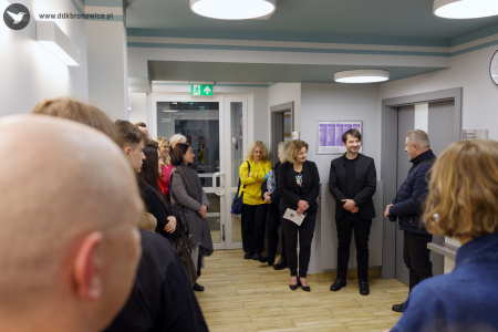 Galeria Przechodnia, Pracownie Kultury Dziesiąta. Po lewej i prawej stronie stoją uczestnicy wystawy. W środku stoi dyrektor dzielnicowego domu kultury Bronowice, pani Aleksandra Szulc-Choma.