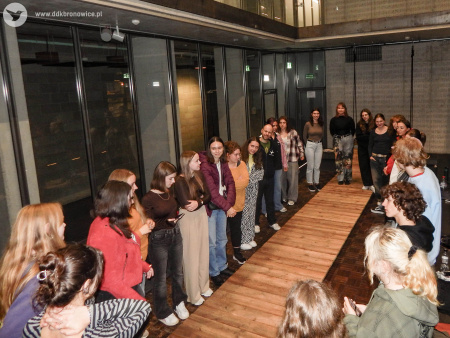 Centrum Spotkania Kultur. Grupa uczestników i uczestniczek stoi w kręgu.