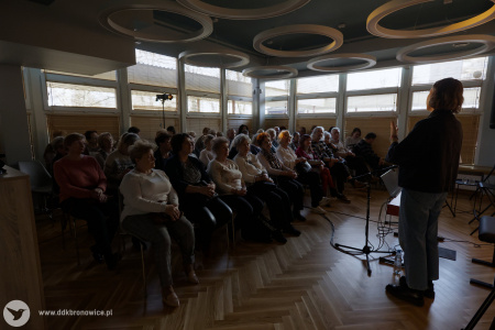 Pracownie Kultury Dziesiąta. Po prawej stronie Agata Pawłowska wita przybyłą widownię. Widownia siedzi po lewej stronie. W tle duże okna. Na suficie okrągłe lampy.