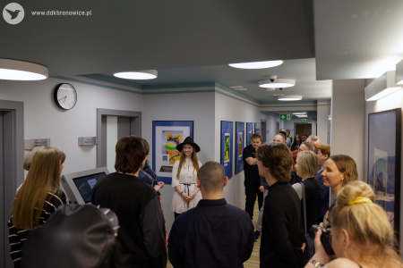 Pracownie Kultury Dziesiąta. Galeria Przechodnia. Na pierwszym planie uczestnicy wystawy. W tle Oleksandra Khodakivska w białej koszuli i czarnym kapeluszu.