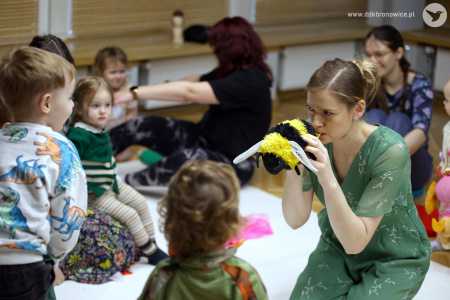 Sylwia Namroży trzyma w rękach pluszową pszczołę. Rozbawia dwójkę dzieci.