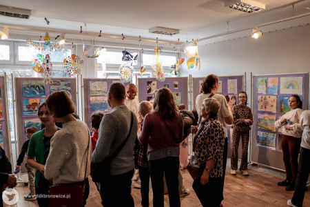 Galeria Mała. Duża grupa osób ogląda obrazy. Widać dzieci, ale też osoby dorosłe.
