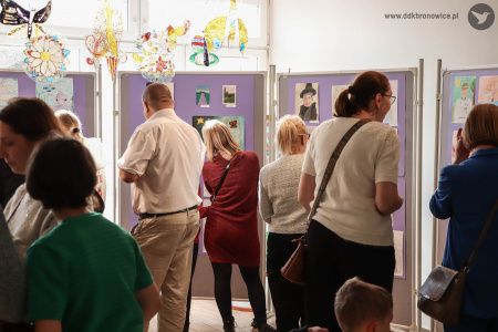 Rodzice oglądają razem z dziećmi obrazy.