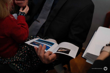 Mężczyzna ogląda folder dotyczący wystawy.