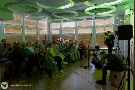 Sala w Pracowniach Kultury Dziesiąta. Po prawej stronie muzycy grają koncert. Po lewej stronie, widownia w skupieniu słucha.