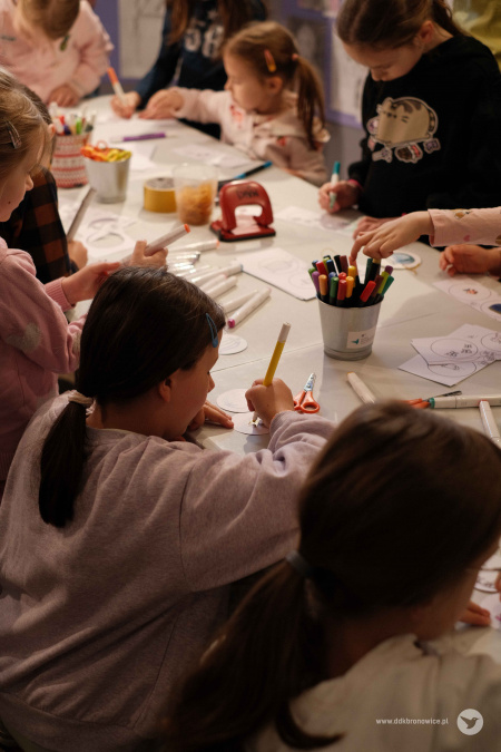 Dzieci malują kolejne fragmenty ozdoby. Na stole kubki z flamastrami.