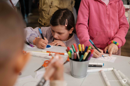 Dziewczynki w różowych bluzach kolorują fragmenty ozdoby.