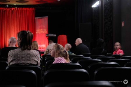 Sala teatralna w Pracowniach Kultury Maki. Na scenie czerwony materiał z napisem: Magic Show.