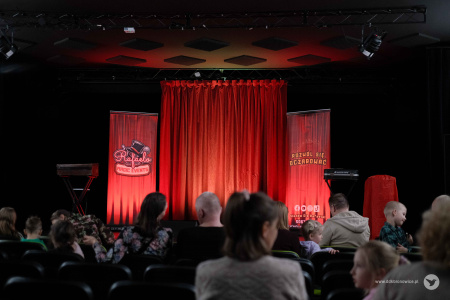 Na scenie czerwona kurtyna i logotypy Magika. Na pierwszym planie zbiera się widownia.