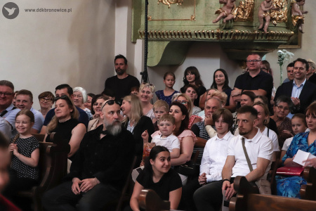 Siedząca publiczność. Wszyscy wyczekują rozpoczęcia koncertu.