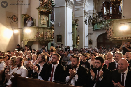 Widownia bije brawo. Po prawej stronie siedzą absolwenci Chóru Chłopięcego „Słowiki Lubelskie". Na koncert przyszło bardzo dużo osób.