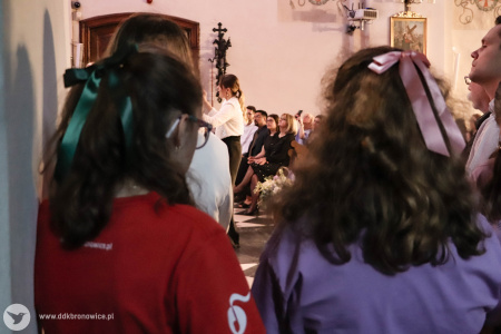 Dwie dziewczynki słuchają koncertu. We włosach mają wpięte kolorowe wstążki.