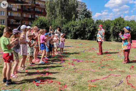 dwa klauny przemawiają do mikrofonów do dzieci. Dzieci grzecznie słuchają i znów próbują naśladować ruchy klauna w niebieskim meloniku.
