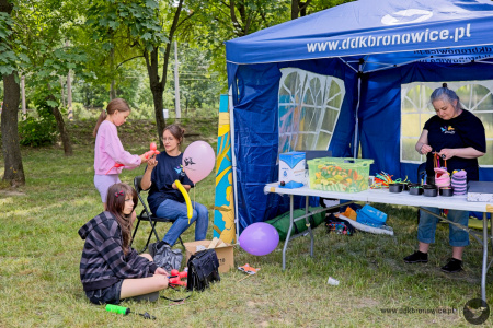 Namiot warsztatowy. Dzieci pod okiem instruktora tworzą małe ozdoby.