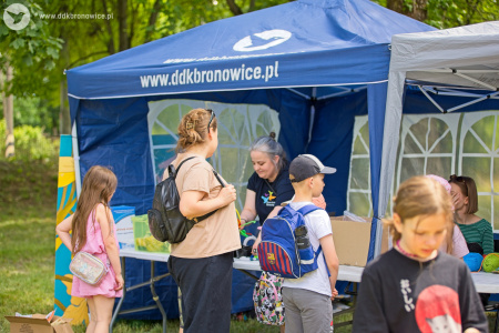 Namiot warsztatowy. Dzieci pod okiem instruktora tworzą małe ozdoby.