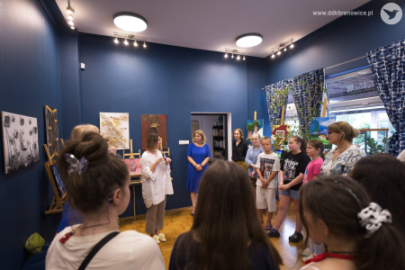 Koordynatorka Galerii w pasażu, Aleksandra Machowska-Skrocka wygłasza przemówienie. Ubrana jest w biała koszulę. Po lewej stronie autorki prac artystycznych.
